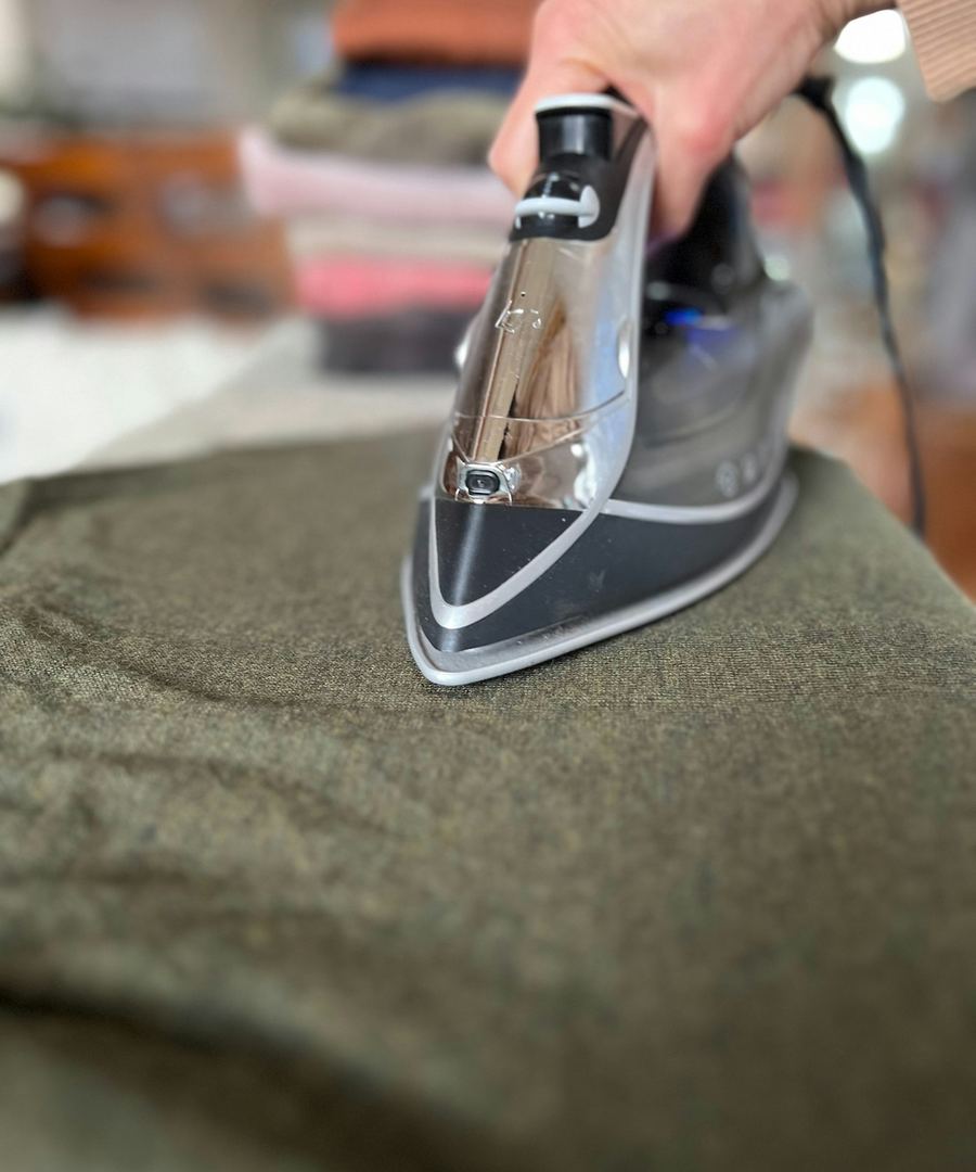 A garment being pressed by hand