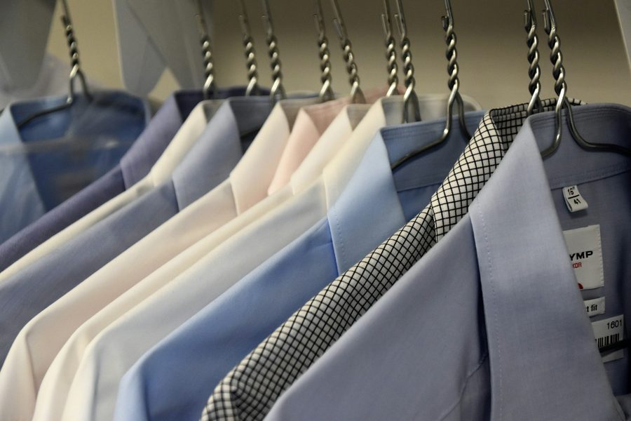 Row of pressed dress shirts and suit jackets on hangers