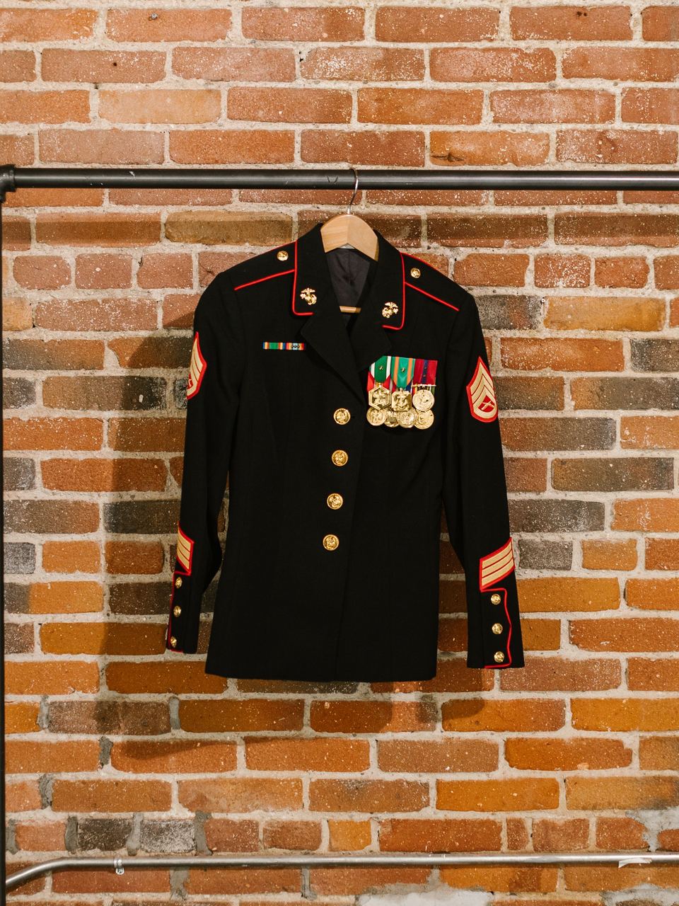Military dress uniform coat with medals hanging on a clothing rack