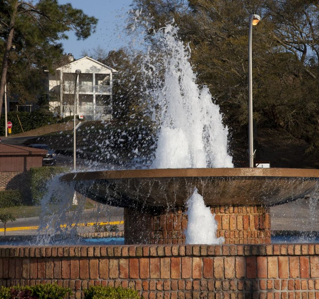 The fountain in Fairhope, Alabama, framed by oak and pine trees