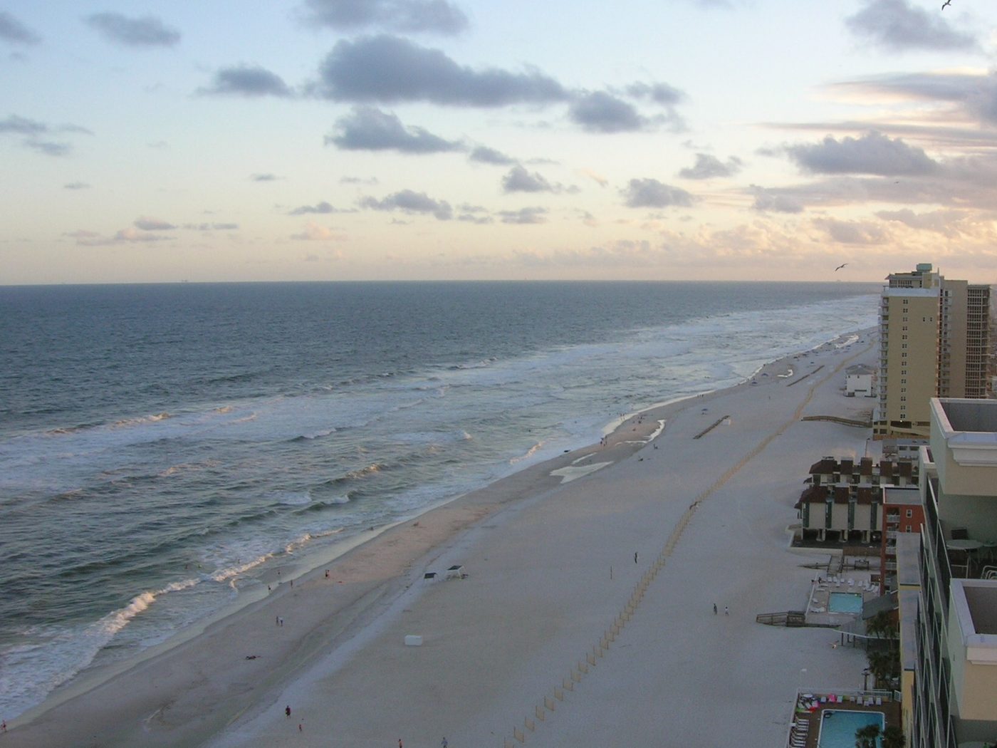 White sand beach and Gulf of Mexico surf along the Gulf Shores, Alabama shoreline at sunset